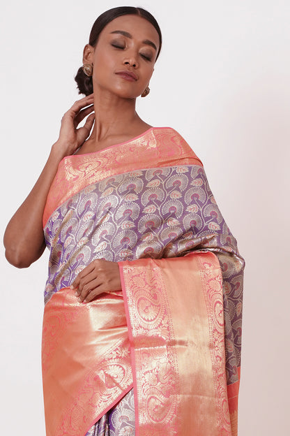 Violet Dharamavaram Silk Saree with thick intricate Peach Border and a Peach Blouse with all over Silver Zari Embroider